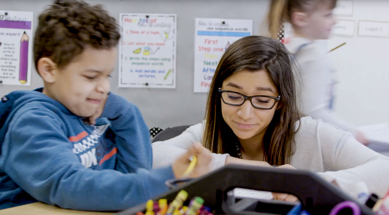 Photo: Student-teacher Yazmin in her first grade classroom surrounded by her students